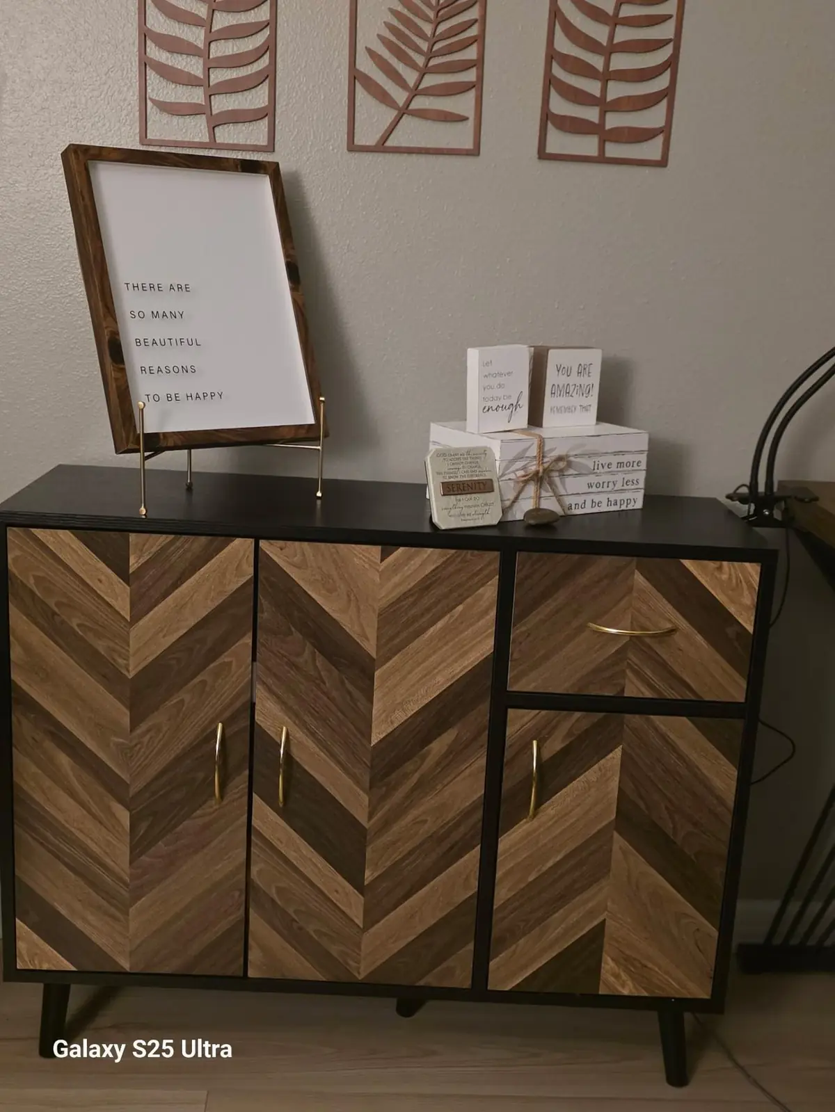 Chevron-wood cabinet with 'reasons to be happy' framed print and inspirational décor